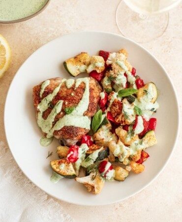 Куриные бедра на противне с овощами и чесночно-травяным соусом